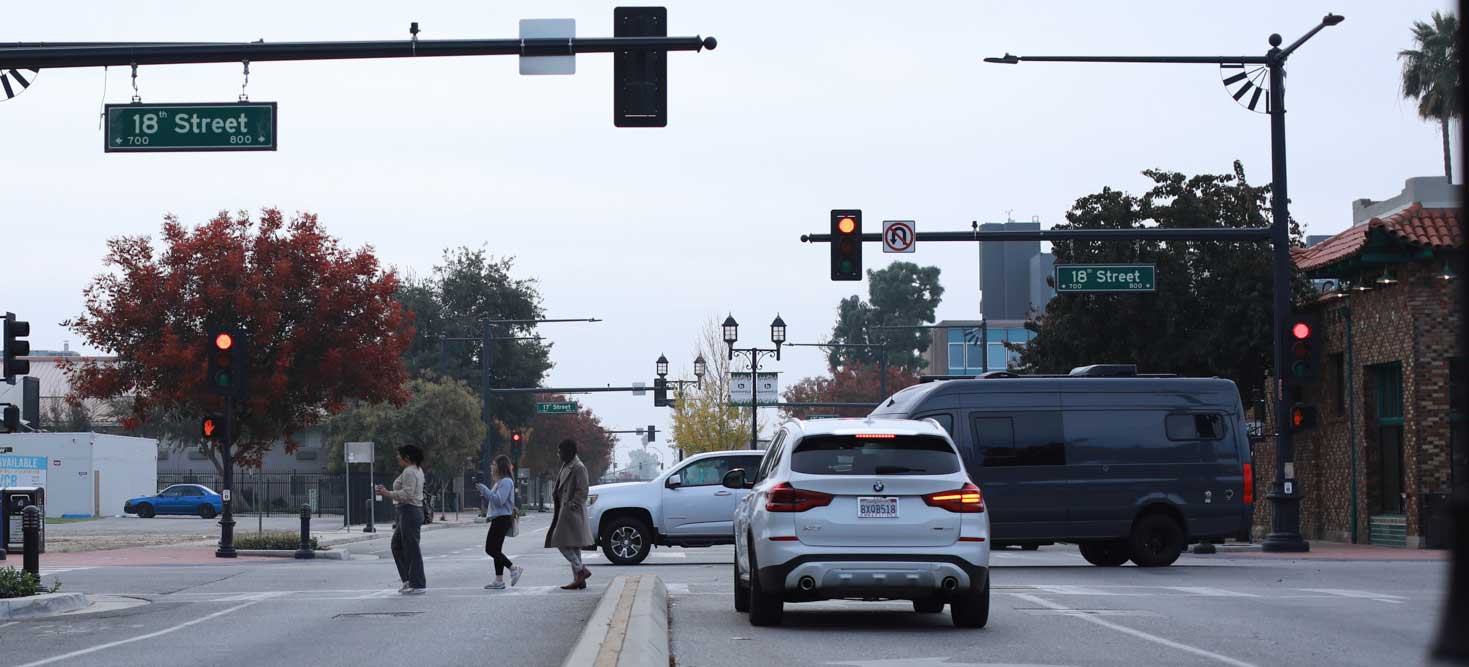 Pedestrians crossing Q Street at the 18th Street intersection in Bakersfield.